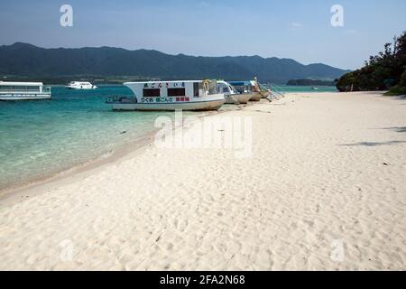 Barche ormeggiate in acque turchesi sul bordo di sabbia bianca a Kabira Bay, Isola di Ishigaki, Okinawa, Giappone Foto Stock