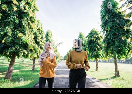 Due ragazze teenage musulmane in velo che fanno sport all'aperto insieme poco prima di rompere il veloce Foto Stock