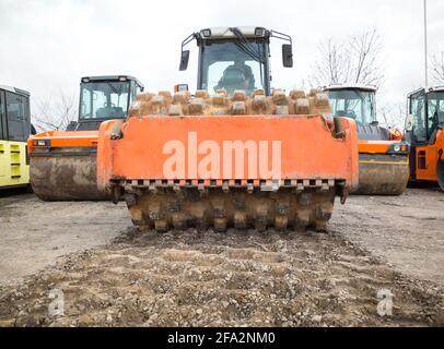 compattatore vibrante grande per impieghi gravosi per la compattazione del terreno. Altri veicoli stradali in background. Attrezzature per il miglioramento, la costruzione e la strada Foto Stock