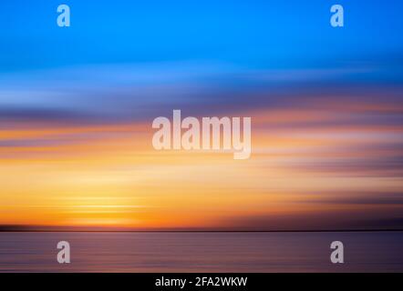 Tramonto sul mare calmo con un cielo molto colorato Foto Stock
