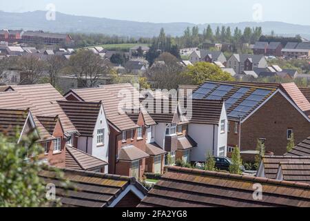 Guardando attraverso i tetti delle case di nuova costruzione a Pinhoe Exeter, Devon, con pannelli solari visibili. Nuova casa edificio, proprietà. Foto Stock