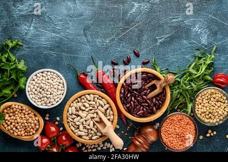 Legumi, lenticchie, ceci, assortimento di fagioli, gustosi ingredienti appetitosi spezie alimentari per cucinare sana cucina su tavola blu. Dieta di perdita di peso Foto Stock