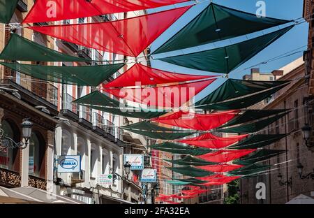Una foto delle colorate coperture del sole che decorano una strada a Madrid. Foto Stock