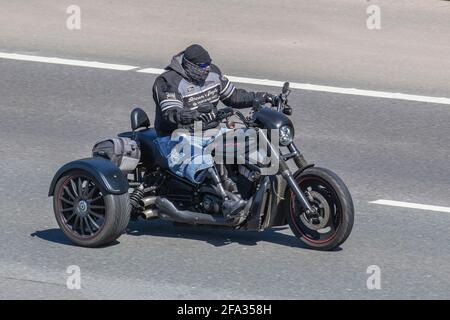 Motociclista disabile indossando una protesi un sostituto artificiale di un arto mancante gode di un giro fuori sul suo Harley-Davidson Trike in condizioni di sole luminoso come le temperature raggiungono 15C + sull'autostrada M6. Credit: MediaWorldImages/AlamyLiveNews Foto Stock