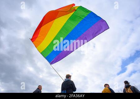 Magdeburgo, Germania. 22 Apr 2021. Partecipanti al rally dell'alleanza ' Unteilbar Sachsen-Anhalt' stand con una bandiera arcobaleno sventolante sulla Domplatz. In vista delle elezioni statali, che si terranno il 6 giugno 2021, l'alleanza della società civile aveva organizzato il raduno. Il contesto è la crescente mobilitazione di attori di estrema destra e la pandemia di Corona in corso, secondo l'alleanza. Credit: Klaus-Dietmar Gabbert/dpa-Zentralbild/dpa/Alamy Live News Foto Stock