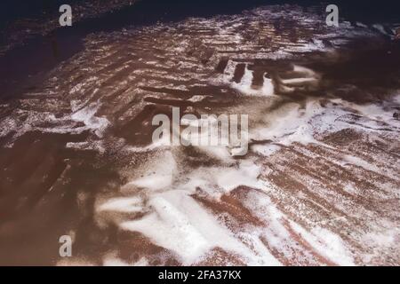 Resti di concime bianco durante lo scarico del carro e tracce di veicoli industriali, nitrato di ammonio. Foto Stock