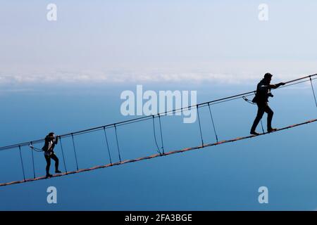 Sagome di figlia e padre sul ponte. Il cielo è sullo sfondo Foto Stock