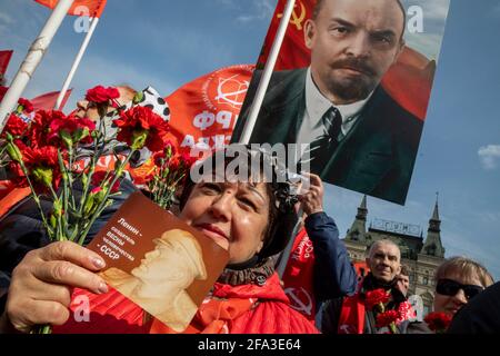 Mosca, Russia. 22 aprile 2021 i sostenitori comunisti russi camminano per visitare il Mausoleo del fondatore sovietico Vladimir Lenin per celebrare il 151° anniversario della sua nascita, in Piazza Rossa nel centro di Mosca, Russia. La bandiera recita 'Lenin - il creatore della primavera dell'umanità - URSS' Foto Stock