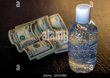 Gel alcol e contanti (dollari). Foto Stock