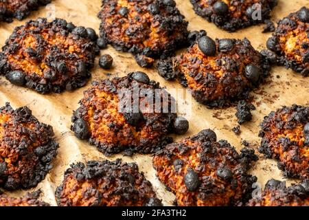 Biscotti di roccia fatti in casa bruciati o biscotti su carta da forno Foto Stock