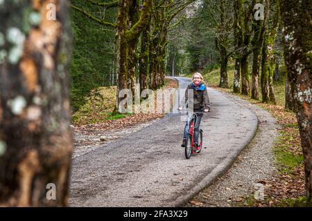 Dopo la facile escursione lungo il fiume Oy da Oberstdorf alla locanda, la strada asfaltata di ritorno è meglio fare con gli scooter a noleggio. Oberstdorf, Germania Foto Stock