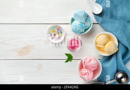 Gelato alla fragola, alla banana e alla mora su sfondo bianco di legno. Vista dall'alto, spazio di copia. Dessert freddo. Foto Stock