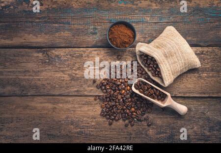 Caffè macinato e chicchi di caffè su sfondo marrone di legno. Vista dall'alto, orizzontale. Foto Stock
