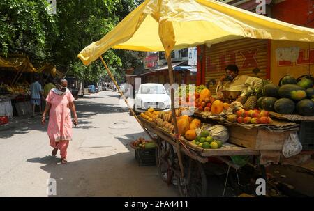 Nuova Delhi, India. 22 Apr 2021. I pendolari acquistano frutta da un fornitore di strada durante la chiusura del fine settimana. Il paese sta affrontando la seconda ondata di coronavirus. L'India ha registrato 314,835 nuovi casi di Covid-19, i più alti mai in un conteggio di un solo giorno e 2,104 morti e 178,841 recuperi nelle ultime 24 ore, come da aggiornamento da parte del Ministero della Salute indiano. Credit: SOPA Images Limited/Alamy Live News Foto Stock