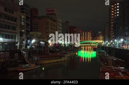 Tokyo, Giappone - Ottobre 16 2020: Vista notturna di un certo numero di barche ormeggiate lungo il fiume Kanda nel centro di Tokyo, con un ponte illuminato visibile Foto Stock