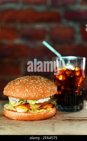 Hamburger rustico fatto a mano e cola su un muro di mattoni sfondo. Foto Stock