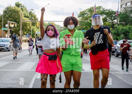 Un gruppo di giovani manifestanti marcia in città strada tra folla Foto Stock
