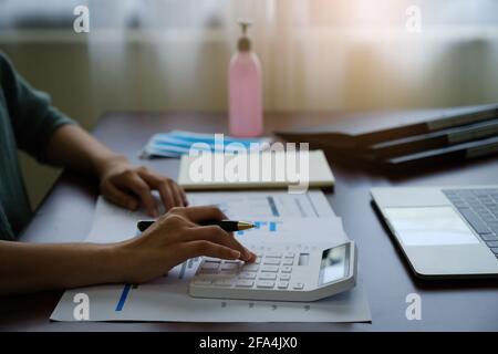 Donna di affari che lavora dalla calcolatrice e remotamente da casa. Concetto contabile, fiscale, finanziario, di audit. Foto Stock