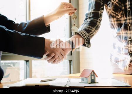 Agente immobiliare e clienti scuotendo insieme le mani celebrando il contratto finito dopo circa assicurazione domestica e prestito di investimento, stretta di mano e. Foto Stock
