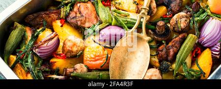 Carne al forno con patate, mele, funghi e okra.Carne arrosto con ortaggi. Banner lungo Foto Stock