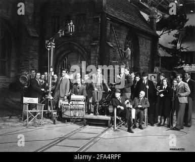 Sul set candido ritratto della squadra di film compreso il cinematografo FREDDIE YOUNG (occhiali davanti alla macchina fotografica) regista SAM WOOD (seduto davanti al cappello) e il produttore VICTOR SAVILLE (reggendo in piedi canna da zucchero vestito overcoat) durante le riprese presso gli studi di Denham di Arrivederci, SIG. CHIPS 1939 regista SAM LIBRO DI LEGNO James Hilton sceneggiatura R.C. Sherriff Claudine West e Eric Maschwitz art direction Alfred Junge produttore Victor Saville Metro Goldwyn Mayer British Studios Foto Stock