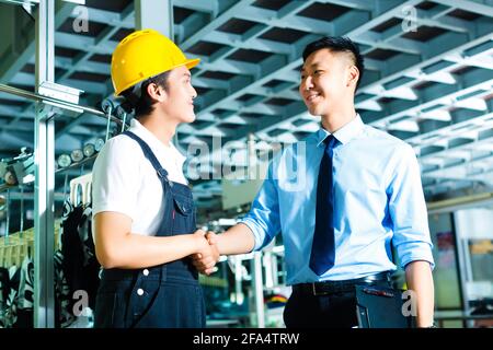 Lavoratore o production manager e proprietario, CEO di controller o agitare le mani in una fabbrica Foto Stock