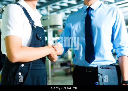 Lavoratore o production manager e proprietario, CEO di controller o agitare le mani in una fabbrica Foto Stock