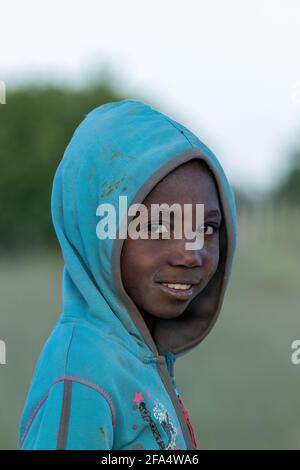 NAMIBIA, REGIONE di OMUSATI, 7 MAGGIO: Ragazza africana in mattina presto freddo sulla strada per la città Opuwo. Namibia settentrionale, 6 maggio 2018, Namibia Africa Foto Stock