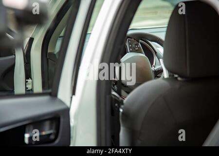 Volante e sedile di guida vuoto della nuova vettura premium suv vista dalla portiera posteriore. Messa a fuoco selettiva. Foto Stock