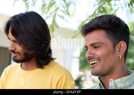 Felice sorridente giovane coppia gay indiana che cammina in un parco Foto Stock