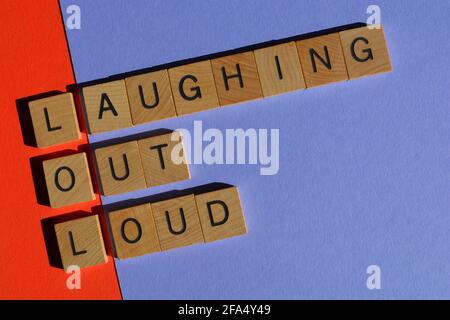 LOL, acronimo di Laughing out Loud in lettere alfabetiche in legno isolate su sfondo colorato Foto Stock