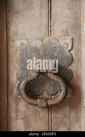 Un Rusty Knocker porta su una vecchia porta di legno edificio. Foto Stock