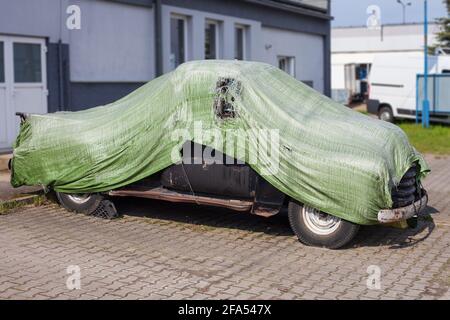 Vecchia auto retrò coperta da telone. Foto Stock