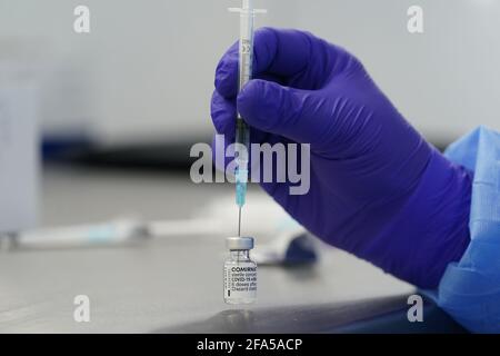 Husum, Germania. 23 Apr 2021. Un assistente medico preleva una siringa con una lattina di vaccino Comirnaty di Biontech nel laboratorio del Centro di vaccinazione Husum. Credit: Marco Brandt/dpa/Alamy Live News Foto Stock