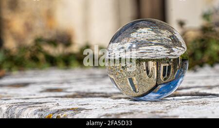Crystal Photo Ball sulla superficie in granito grigio che riflette l'immagine di Chiesa e edificio storico sotto il sole estivo Foto Stock