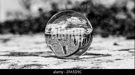 Crystal Photo Ball sulla superficie in granito grigio che riflette l'immagine di Chiesa e edificio storico sotto il sole estivo Foto Stock