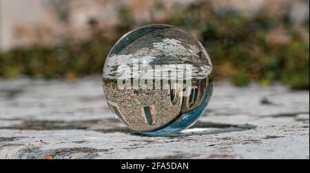 Crystal Photo Ball sulla superficie in granito grigio che riflette l'immagine di Chiesa e edificio storico sotto il sole estivo Foto Stock