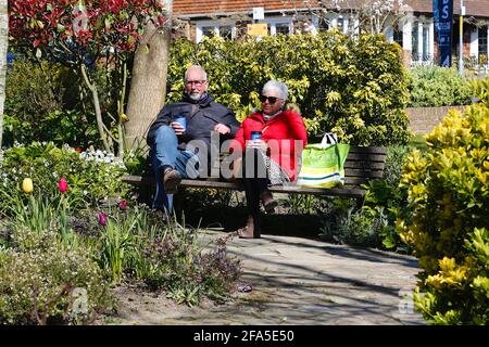 Tenterden, Kent, Regno Unito. 23rd Apr 2021. UK Meteo: Soleggiato nella città di Tenterden nel Kent come le persone uscire e godere del tempo soleggiato ora che alcune delle restrizioni di blocco sono state revocate. Una coppia anziana si siede su una panca rilassandosi al sole bevendo caffè. Photo Credit: Paul Lawrenson /Alamy Live News Foto Stock