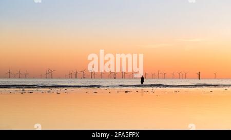 La luce del sole dorata circonda un uomo di ferro ad alta marea sulla spiaggia a Crosby. Questo fa parte di un altro luogo, l'installazione artistica vicino a Liverpool ha costituito Foto Stock