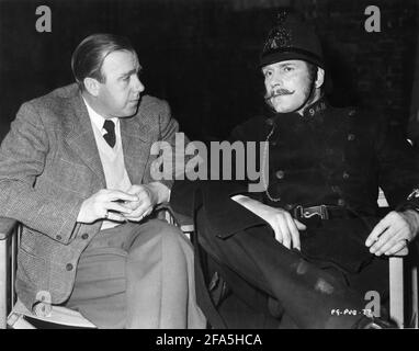 Produttore RONALD NEAME e LAURENCE OLIVIER in costume come polizia Constable 94-B sul set candid durante le riprese DELLA MAGIA BOX 1951 regista JOHN BOULTING sceneggiatura Eric Ambler basato su La biografia Friese-Greene primo piano di un inventore di Ray Produttore di allister Ronald Neame regista Jack Cardiff music William Alwyn Festival Film Productions / British Lion Film Corporation Foto Stock