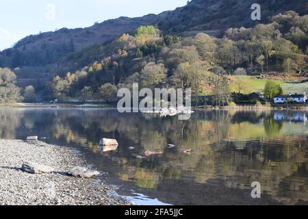 Un'incantevole e tranquilla scena mattutina a Rydal Water, con le colline circostanti che si abbellono fino al lago con splendidi riflessi sulla sua superficie. Foto Stock