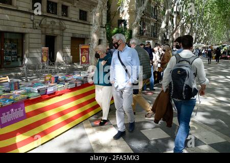 Tradizionale 23 aprile 2021, giorno di Sant Jordi, a Palma di Maiorca con la gente che guarda i libri nelle diverse bancarelle di strada, dove predominano maschere, rose e bottiglie di gel disinfettante. Foto Stock