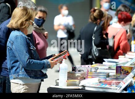 Tradizionale 23 aprile 2021, giorno di Sant Jordi, a Palma di Maiorca con la gente che guarda i libri nelle diverse bancarelle di strada, dove predominano maschere, rose e bottiglie di gel disinfettante. Foto Stock