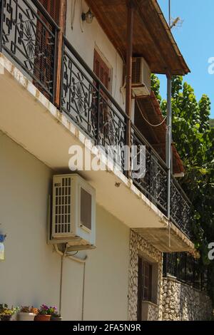 Vasiliki, Grecia - Luglio 24 2019: Architettura di Vasiliki, ristoranti, auto di scuola superiore, mercati con persone a piedi Foto Stock