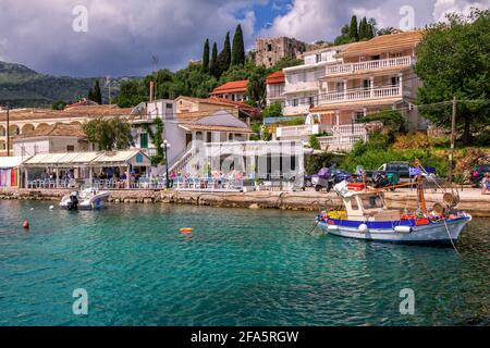 Isola di Corfù/Grecia - 6 maggio 2019: Vista sul bellissimo villaggio di Kassiopi - laguna di mare con acque turchesi calme, barche, case colorate e caffè di strada Foto Stock