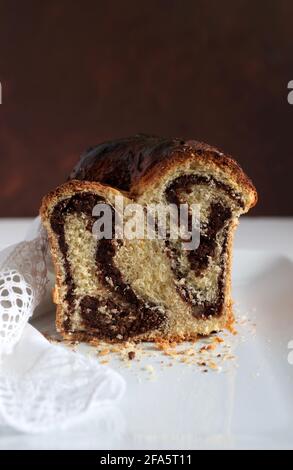 Pane dolce rumeno tradizionale fatto in casa chiamato 'cozonac', con cacao, uvetta e noci. Dessert da forno dell'Europa orientale. Babka. Foto Stock