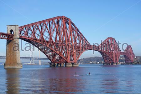 South Queensferry, Scozia, Regno Unito. 23 Aprile 2021. Chiaro caldo e soleggiato a South Queensferry. Le persone che fanno il massimo del bel tempo e iniziano a visitare e godersi la vita all'aria aperta presso i soliti punti di interesse per i visitatori. Paddle boarding sotto il Forth Bridge. Credit: Craig Brown/Alamy Live News Foto Stock