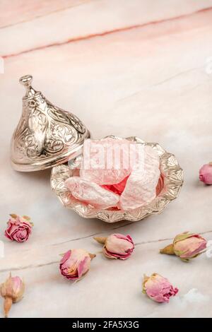 Delizia turca al gusto di rosa sul tavolo decorato con fiori Foto Stock