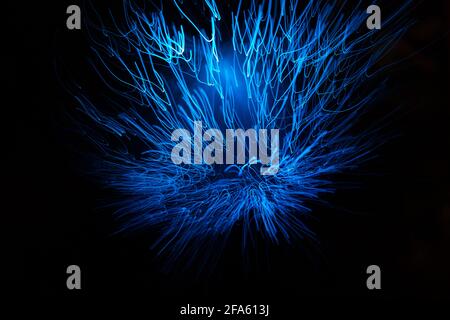 Particelle astratte blu e linee con bokeh e sfocatura su sfondo scuro. Foto Stock