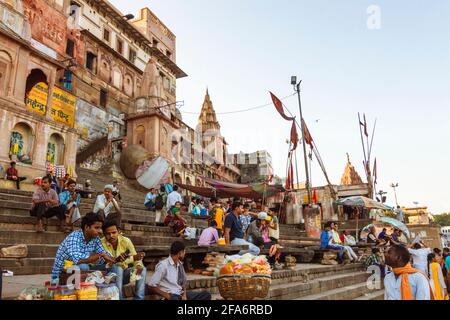 Varanasi, Uttar Pradesh, India : la gente si siede e cammina ai ghiatti lungo il fiume Gange. Foto Stock